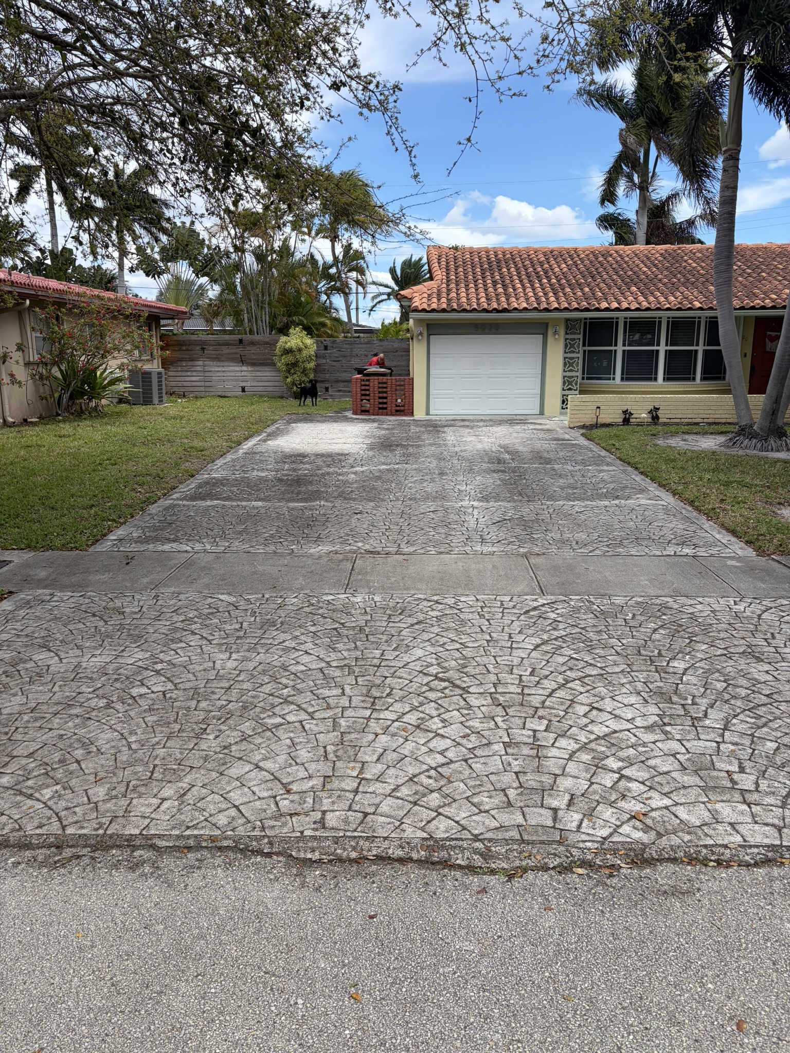 Stamped concrete driveway before pressure washing — dingy with years of mildew and irrigation stains